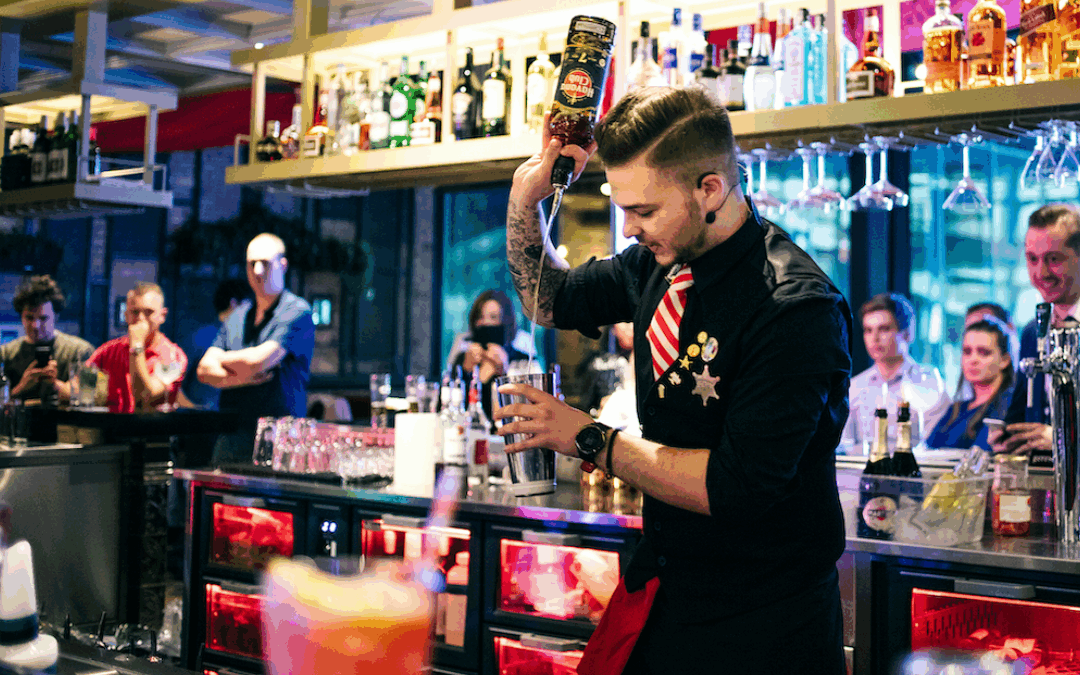 TGI Fridays bartender preparing a festive cocktail at a busy bar during a New Year’s Eve celebration